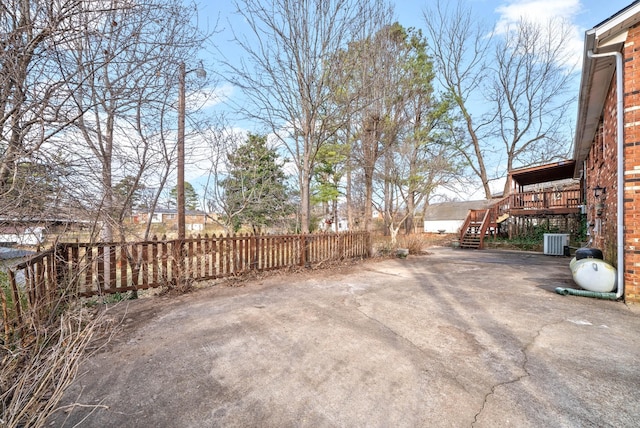 view of yard featuring stairs, a patio, central AC unit, and fence