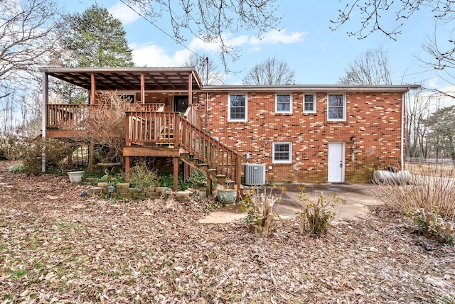 back of house featuring a patio, stairs, a deck, central air condition unit, and brick siding