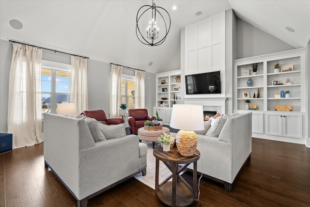 living area with dark wood-style floors, built in shelves, an inviting chandelier, high vaulted ceiling, and a warm lit fireplace