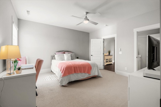 bedroom featuring baseboards, visible vents, a ceiling fan, and light colored carpet