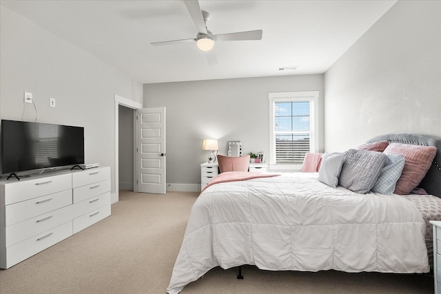 bedroom with light colored carpet, ceiling fan, visible vents, and baseboards