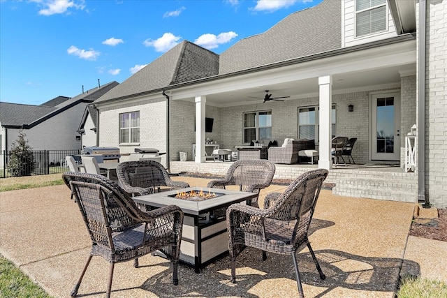 view of patio with fence, grilling area, a ceiling fan, and an outdoor living space with a fire pit