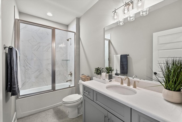 bathroom featuring combined bath / shower with glass door, vanity, and toilet