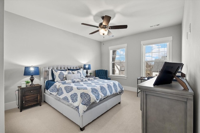 bedroom featuring a ceiling fan, visible vents, light carpet, and baseboards