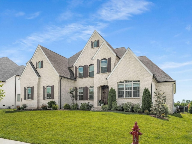 5562 Hardeman Springs Blvd, Arrington, TN 37014 - french country home with brick siding, a front yard, and a shingled roof