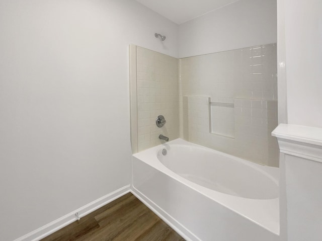 full bathroom featuring shower / washtub combination, baseboards, and wood finished floors