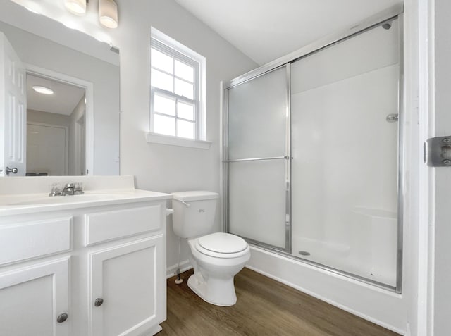 bathroom featuring toilet, a shower stall, vanity, and wood finished floors