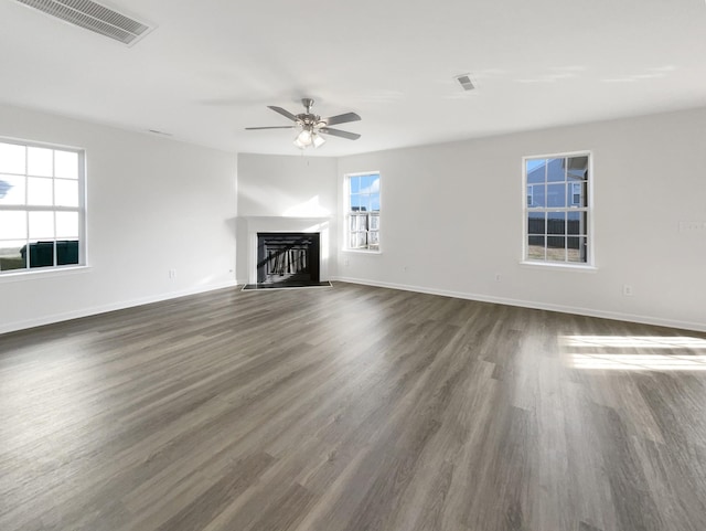 unfurnished living room featuring a fireplace with flush hearth, visible vents, baseboards, and dark wood-style floors