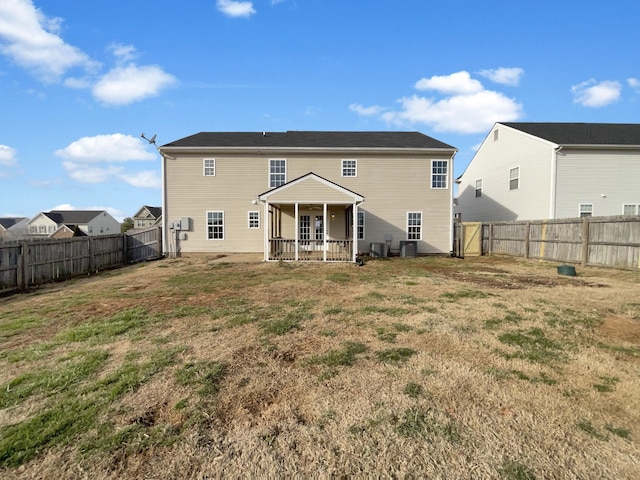 back of house featuring a fenced backyard and a yard