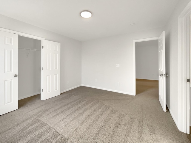 unfurnished bedroom with carpet, baseboards, and a closet