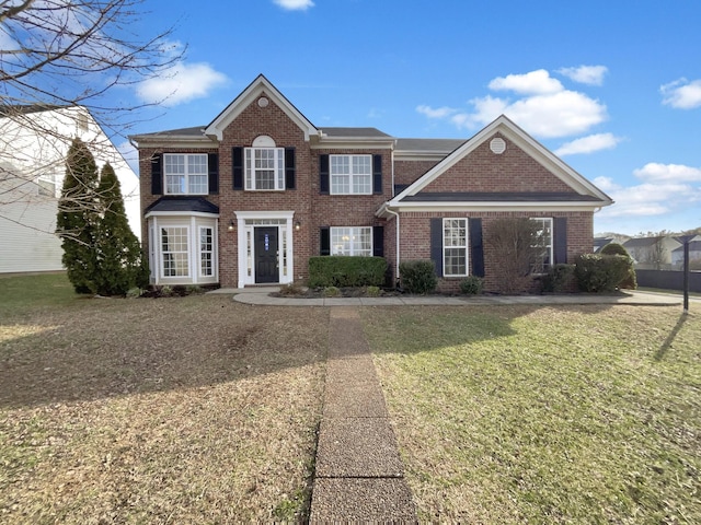 colonial inspired home featuring brick siding and a front lawn