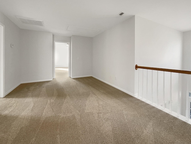 spare room with carpet, visible vents, and baseboards