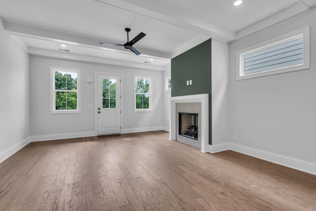 unfurnished living room with a fireplace, baseboards, and wood finished floors