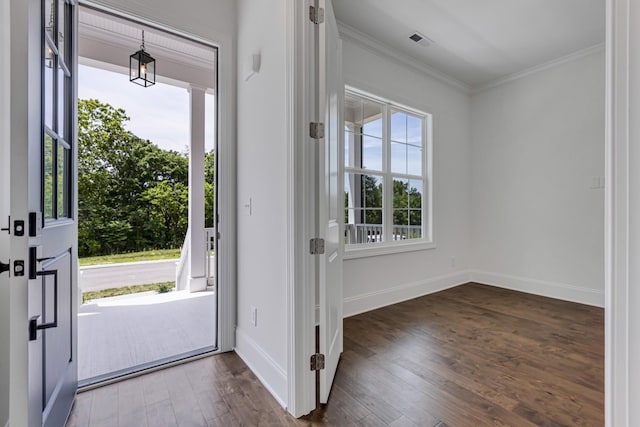 foyer entrance featuring dark wood-style flooring, visible vents, crown molding, and baseboards