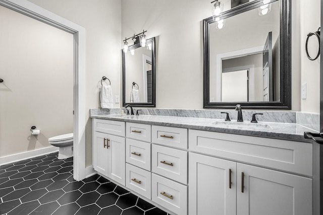 bathroom featuring toilet, tile patterned flooring, double vanity, and a sink