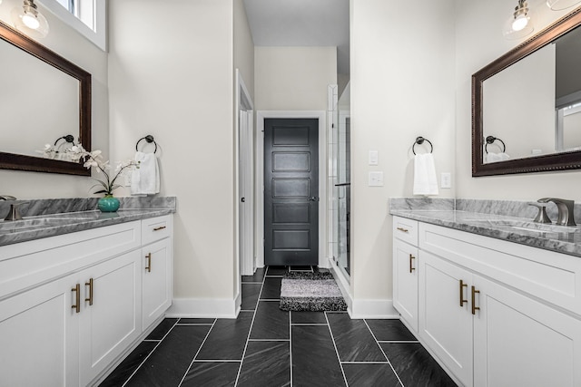 full bath with a shower stall, vanity, and baseboards