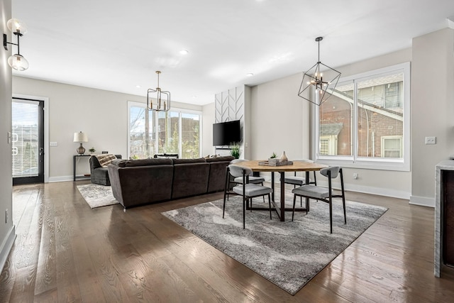 dining area featuring dark wood-style floors, a chandelier, and a wealth of natural light