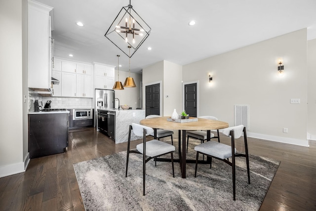 dining room with dark wood-style floors, recessed lighting, visible vents, and baseboards