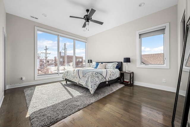 bedroom with ceiling fan, baseboards, visible vents, and dark wood finished floors