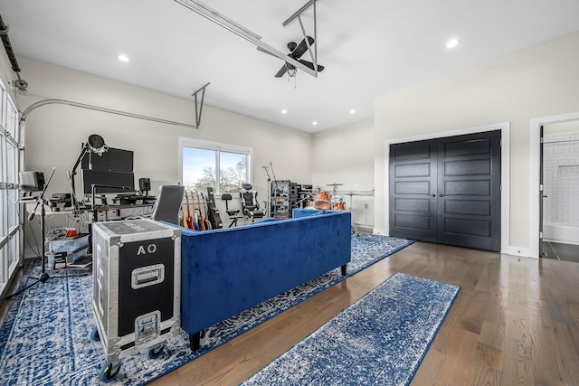 living room featuring a garage, dark wood-style floors, and recessed lighting