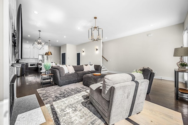 living room with stairs, light wood finished floors, recessed lighting, and an inviting chandelier