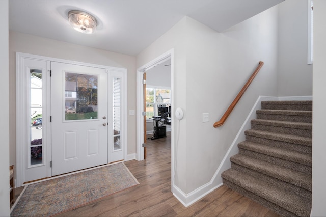 entryway featuring stairway, baseboards, and wood finished floors