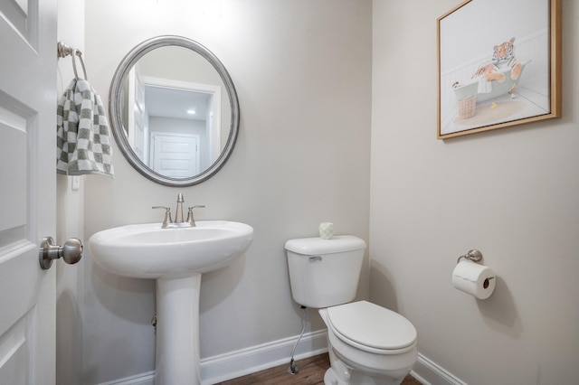 bathroom featuring toilet, baseboards, and wood finished floors