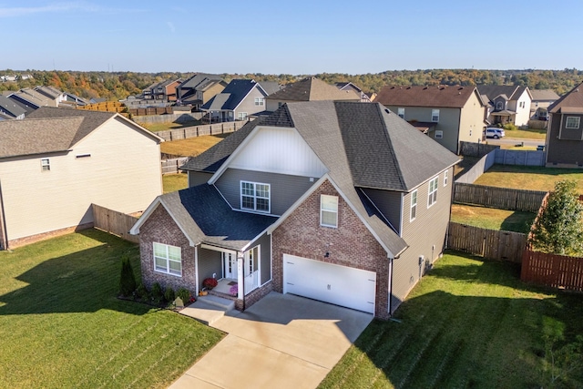 view of front of house featuring a residential view, fence, a front lawn, and concrete driveway