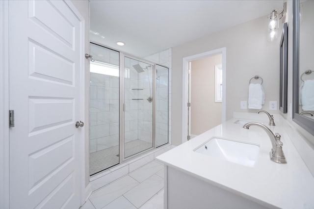 bathroom featuring marble finish floor, double vanity, recessed lighting, a stall shower, and a sink