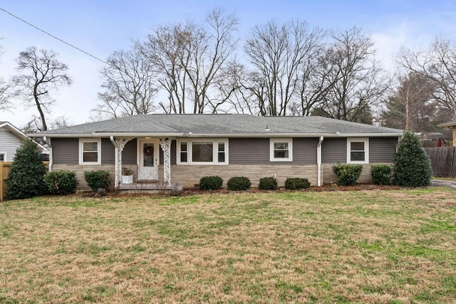 ranch-style house featuring stone siding, a front yard, and fence