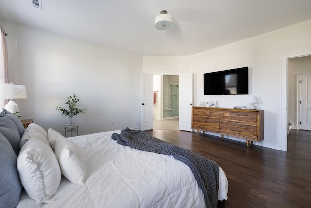 bedroom featuring baseboards, visible vents, wood finished floors, and ensuite bathroom