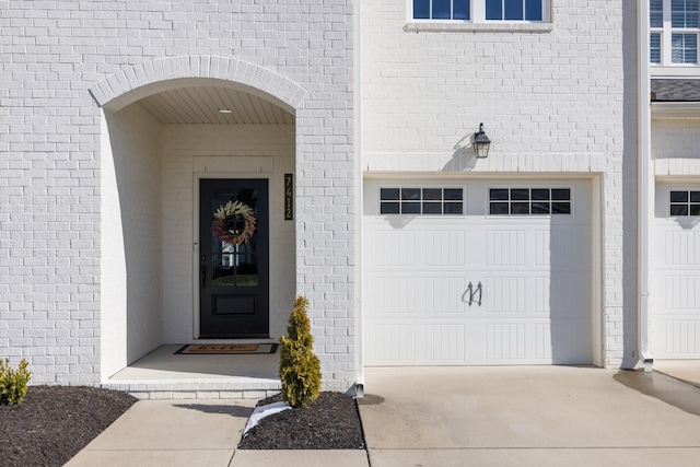 property entrance with driveway and an attached garage