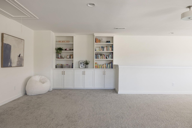 interior space with light carpet, visible vents, attic access, and baseboards