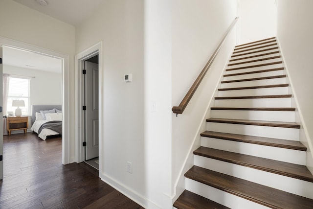 stairs featuring wood finished floors and baseboards