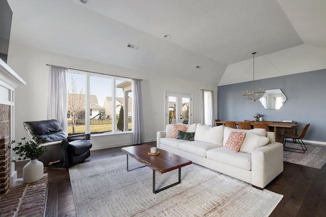 living area featuring lofted ceiling, french doors, dark wood-type flooring, and visible vents