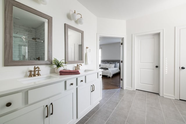 bathroom with double vanity, a stall shower, a sink, and tile patterned floors