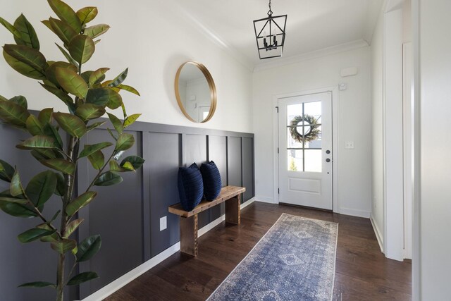 entrance foyer featuring baseboards, crown molding, and wood finished floors