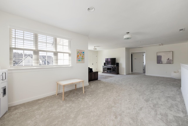 interior space with light carpet, attic access, visible vents, and baseboards