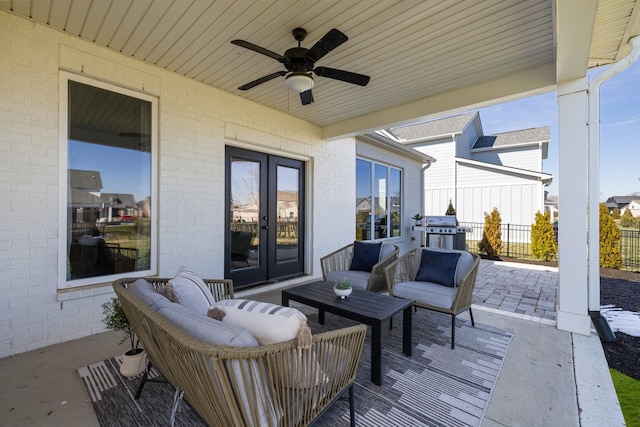 wooden terrace with a ceiling fan, fence, french doors, a patio area, and an outdoor living space