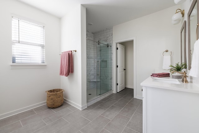 full bathroom featuring a shower stall, baseboards, and vanity