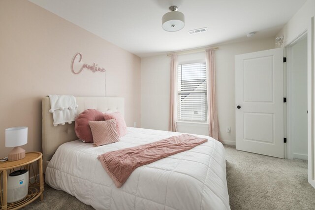 bedroom with visible vents, light carpet, and baseboards