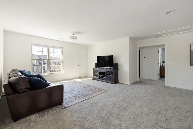 living area featuring carpet floors, attic access, and baseboards