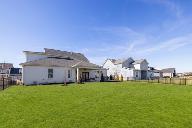 rear view of property with a fenced backyard, a lawn, a patio, and ceiling fan