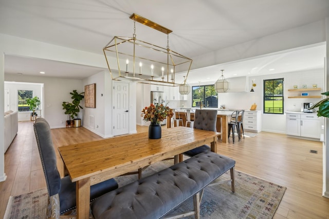 dining area with light wood finished floors, baseboards, and recessed lighting