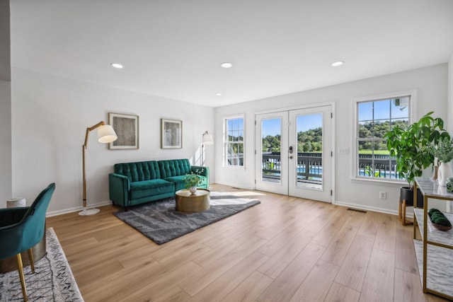 living room featuring baseboards, french doors, light wood finished floors, and recessed lighting