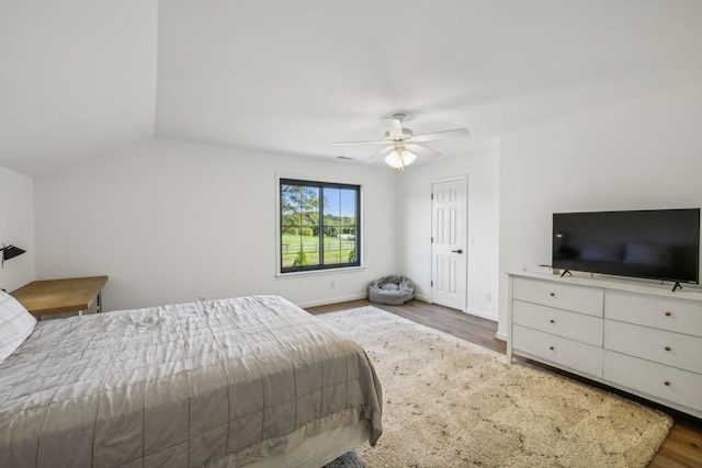 bedroom featuring lofted ceiling, ceiling fan, baseboards, and wood finished floors