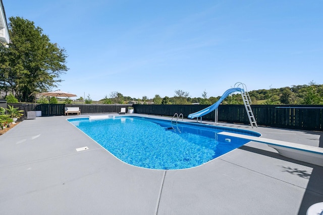 view of swimming pool featuring a water slide, a patio area, fence, and a diving board