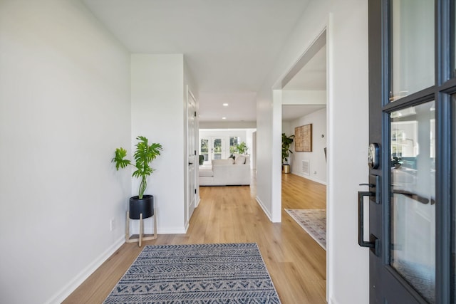 foyer entrance featuring light wood-type flooring, visible vents, and baseboards