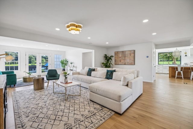 living room featuring french doors, recessed lighting, and light wood-style floors