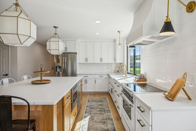 kitchen featuring appliances with stainless steel finishes, light countertops, and white cabinets